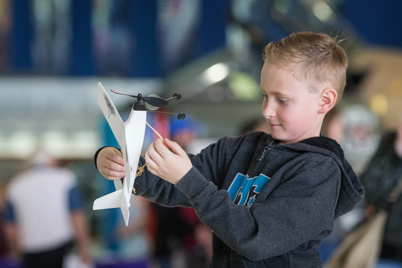 Student holding model airplane