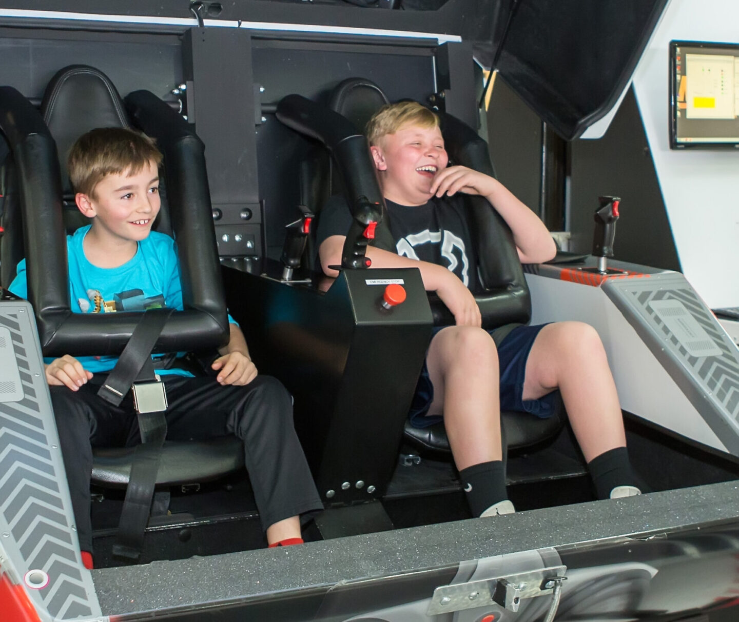 Two boys smiling in the MaxFlight Simulator at the Air & Space Museum