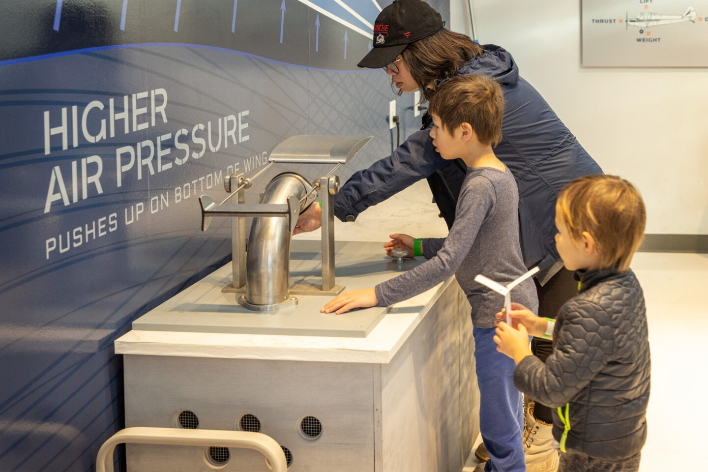 Guests interacting with air pressure exhibit at Exploration of Flight