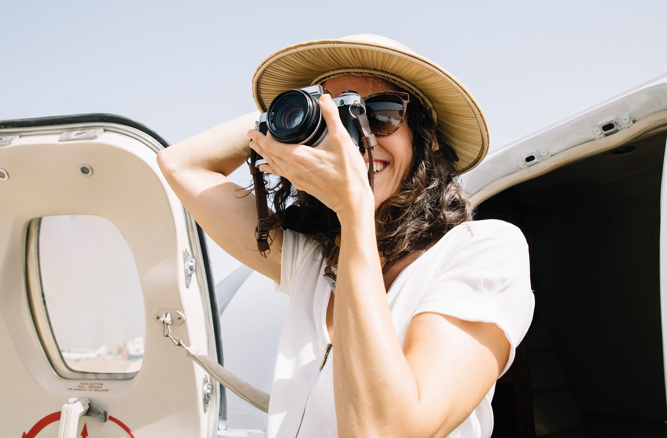 Photographer taking a photo and standing next to airplane