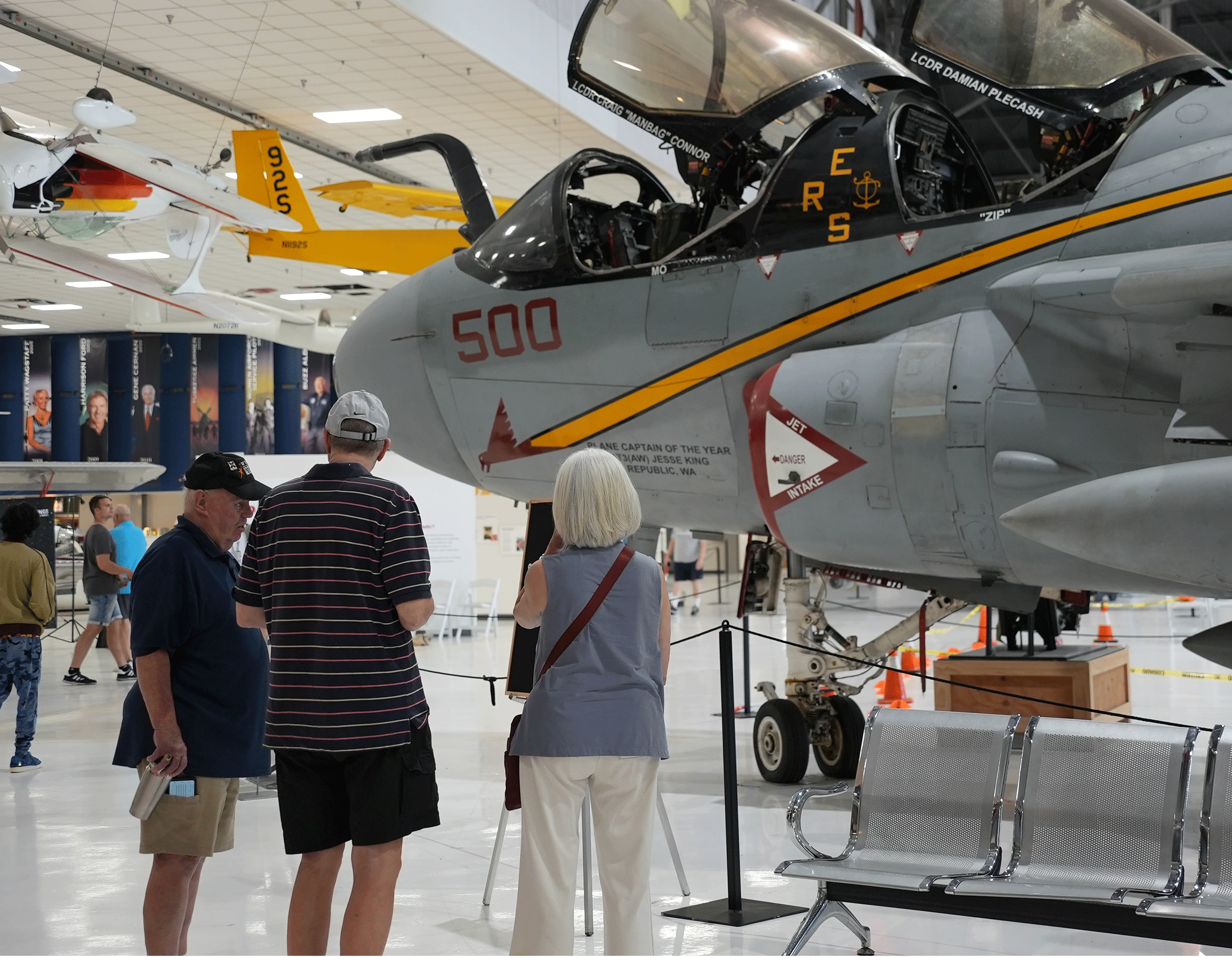 A couple in the museum talking to a volunteer in front of the Prowler