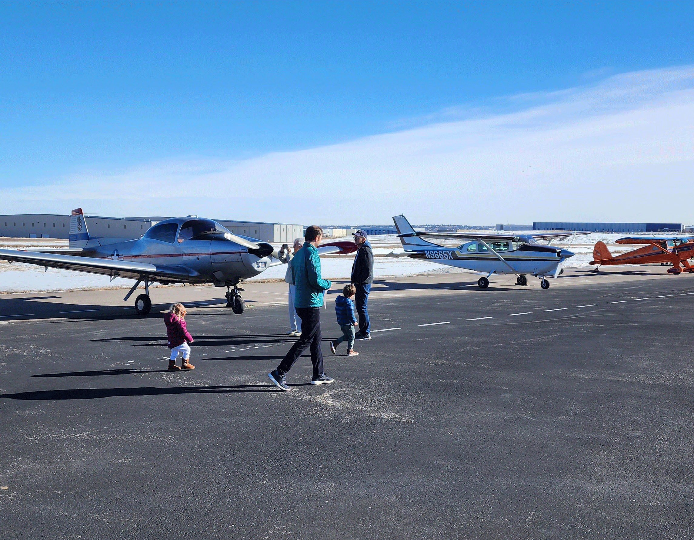 Family checking out airplanes on the ramp at Exploration of Flight