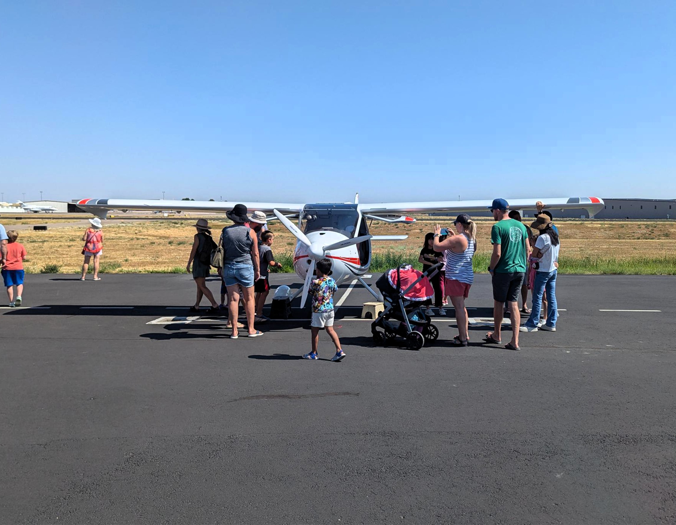 Family views and takes photos of an aircraft on the ramp at Exploration of Flight.