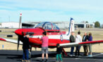 Guests standing by aircraft on the ramp at Exploration of Flight