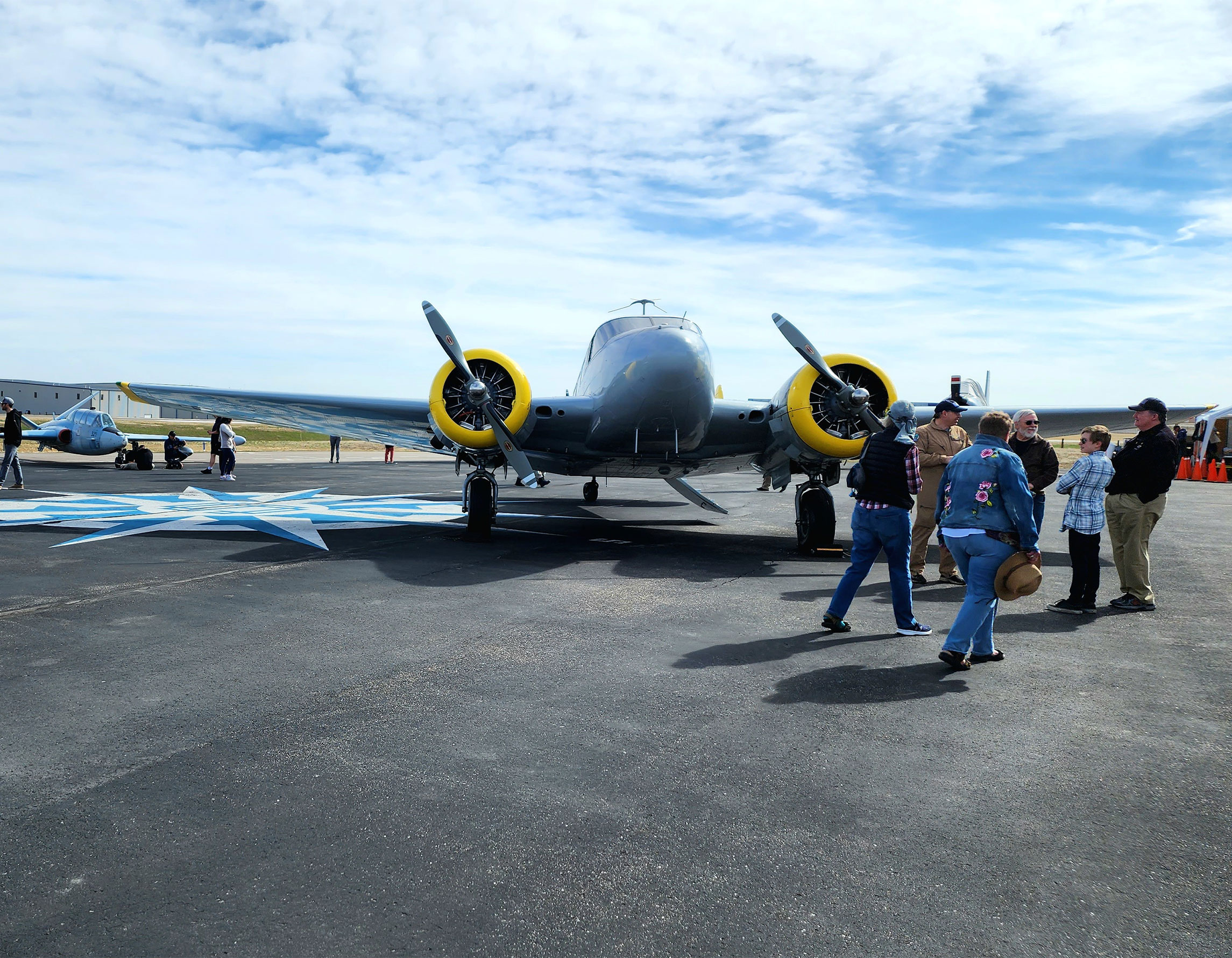 Guests in front of an airplane on the ramp at Exploration of Flight