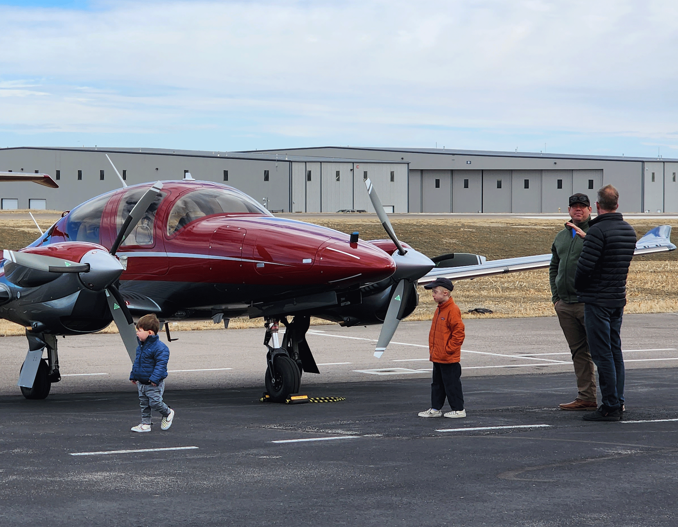 Adults and kids by airplane on the ramp