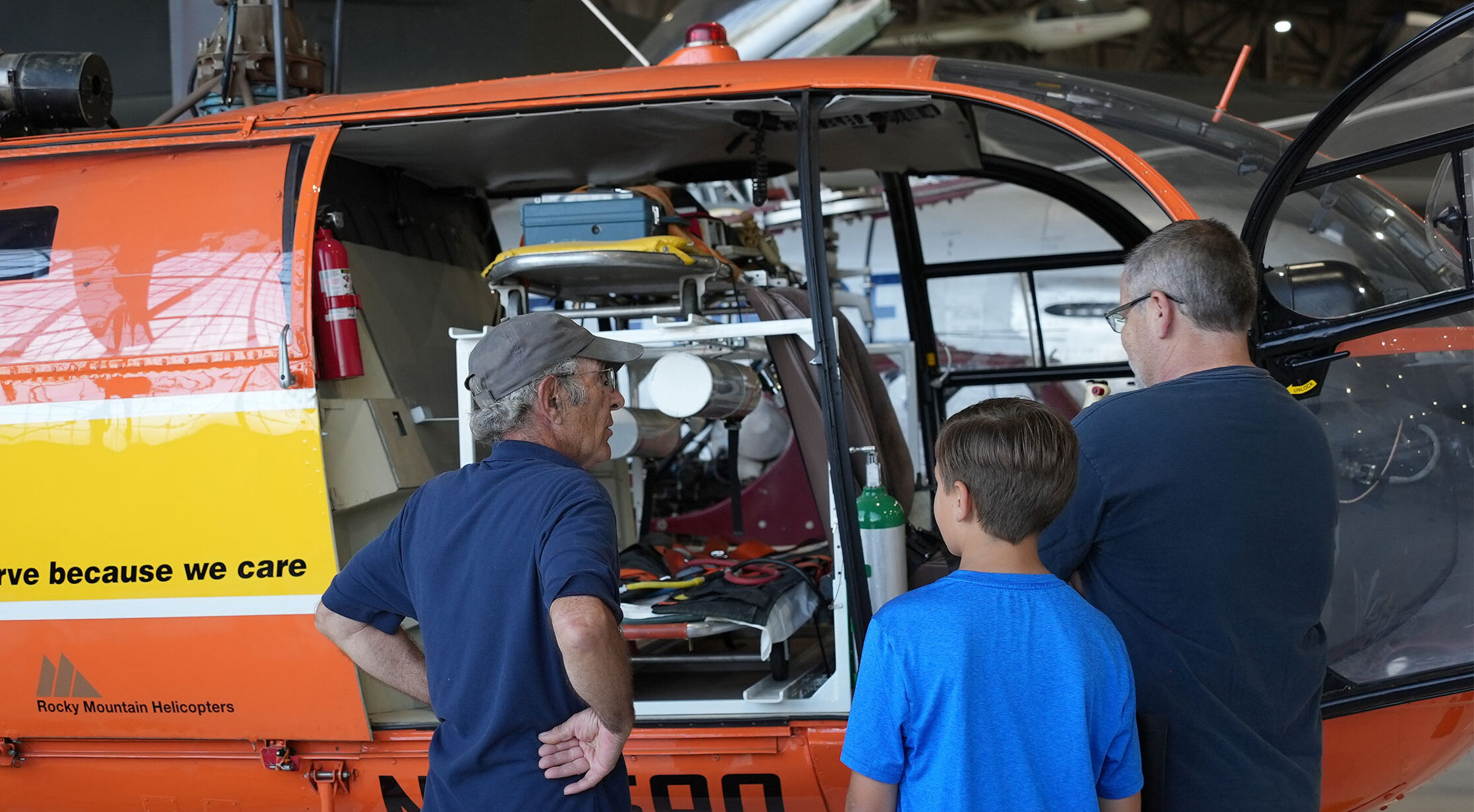 Guests standing with a volunteer looking into the Alouette Helicopter