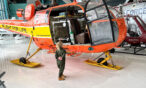 Young girl looking into the cockpit of the Aerospatiale AS316 Alouette III