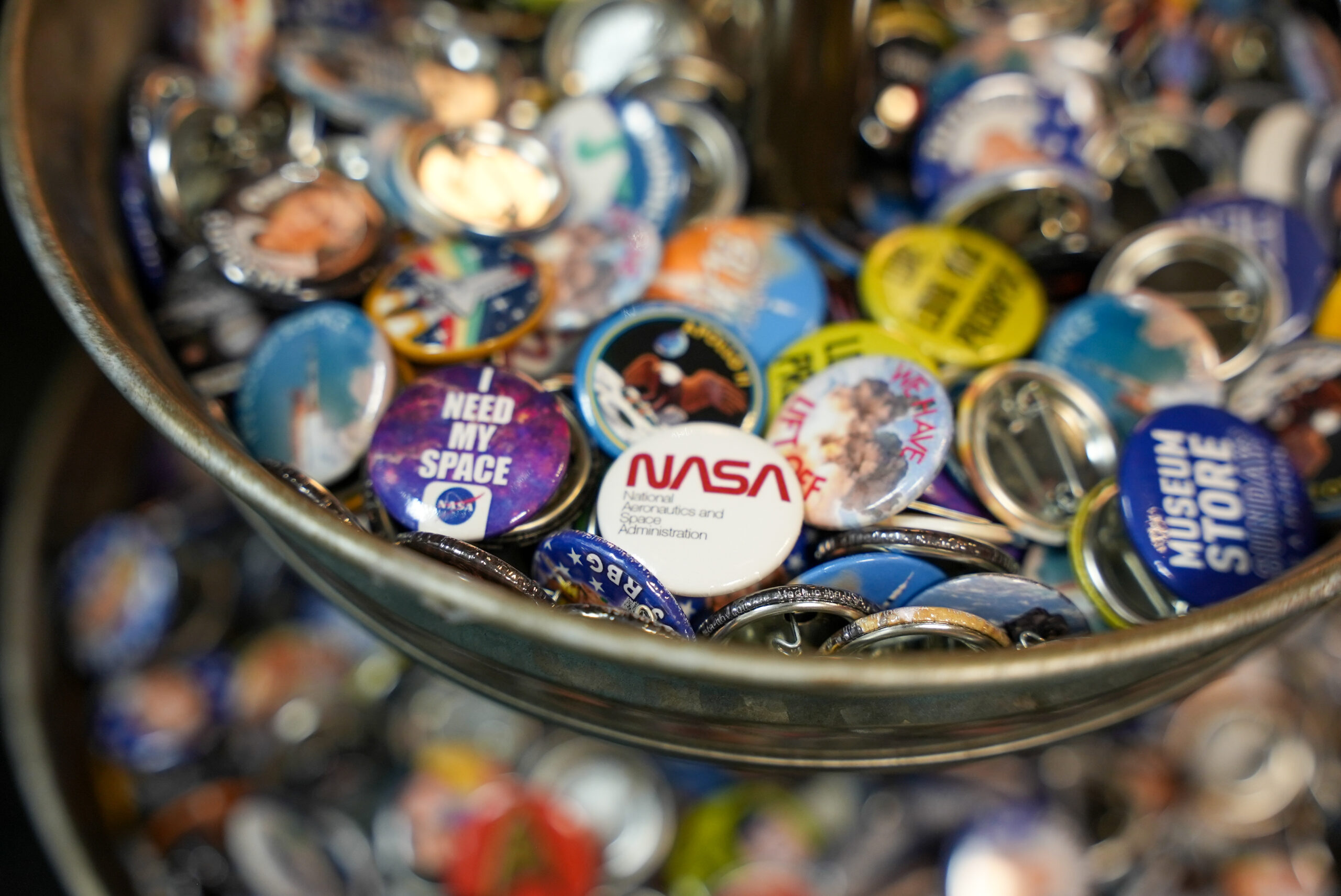 A bowl full of various circular pins.