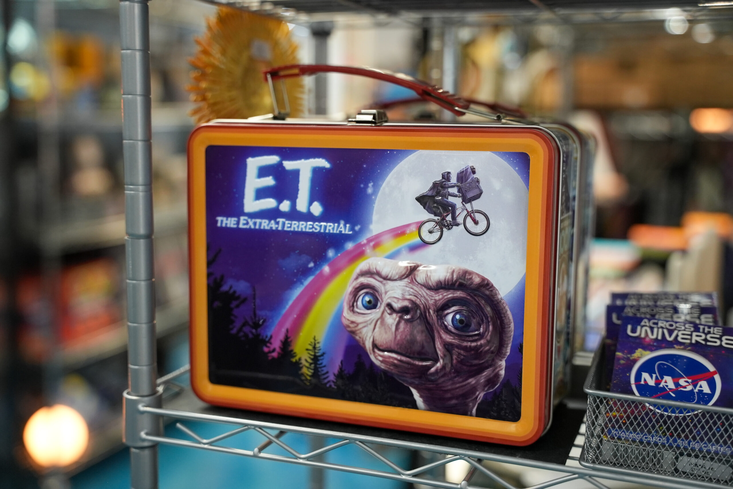 A metal E.T. lunch box sits on a shelf in the museum store.