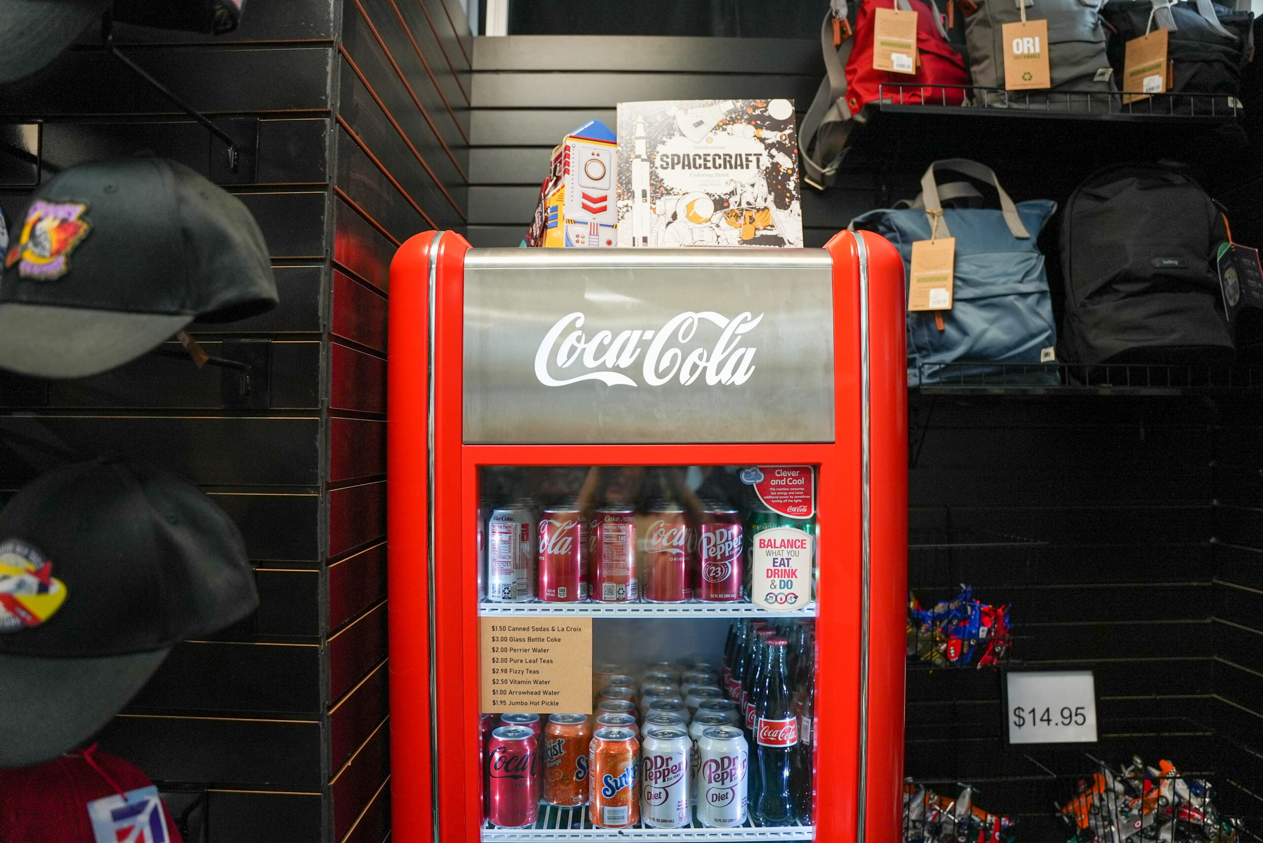 A retro coca-cola fridge is filled with various drinks.