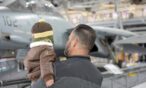Dad holding son and viewing airplane