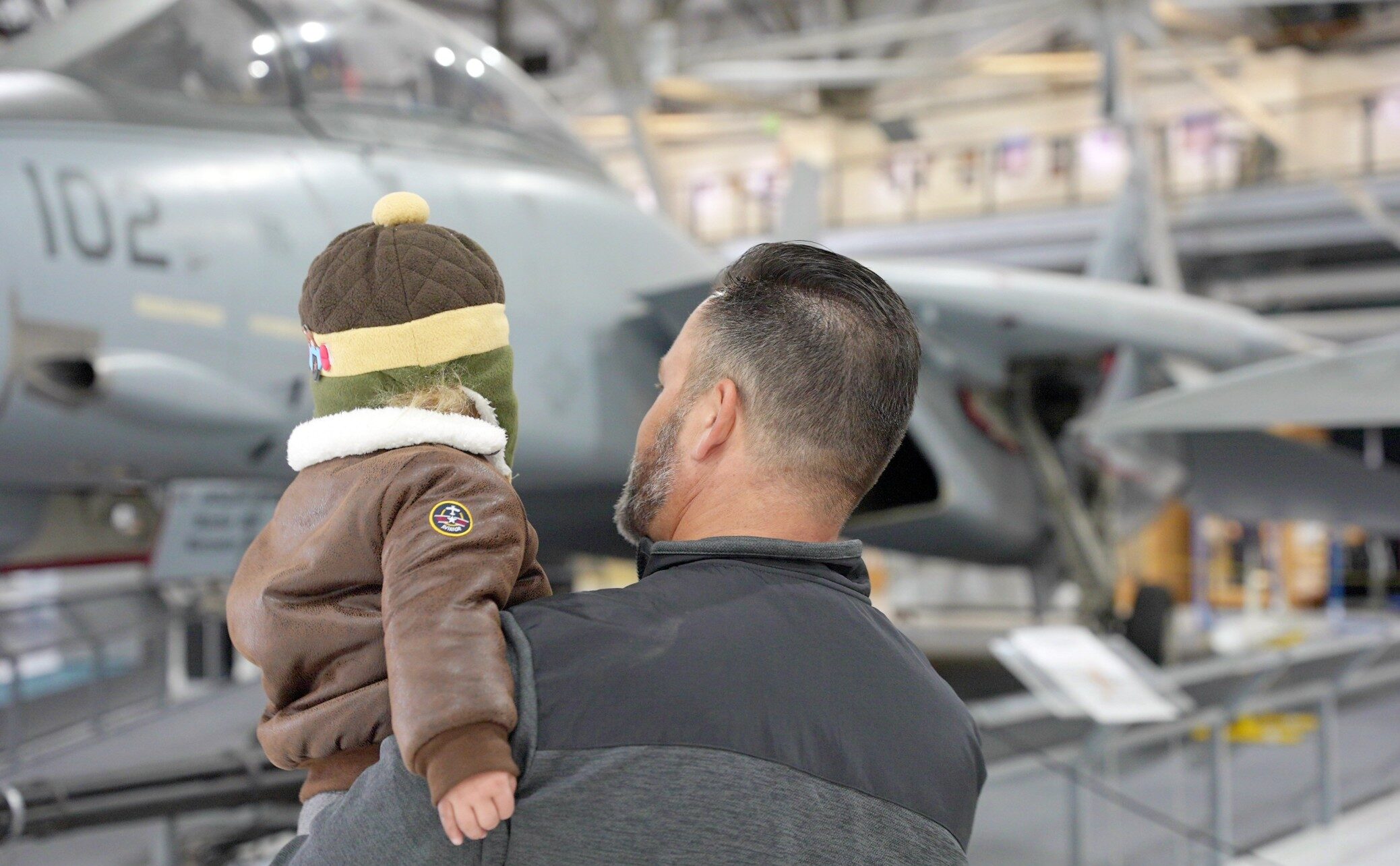 Dad holding son and viewing airplane
