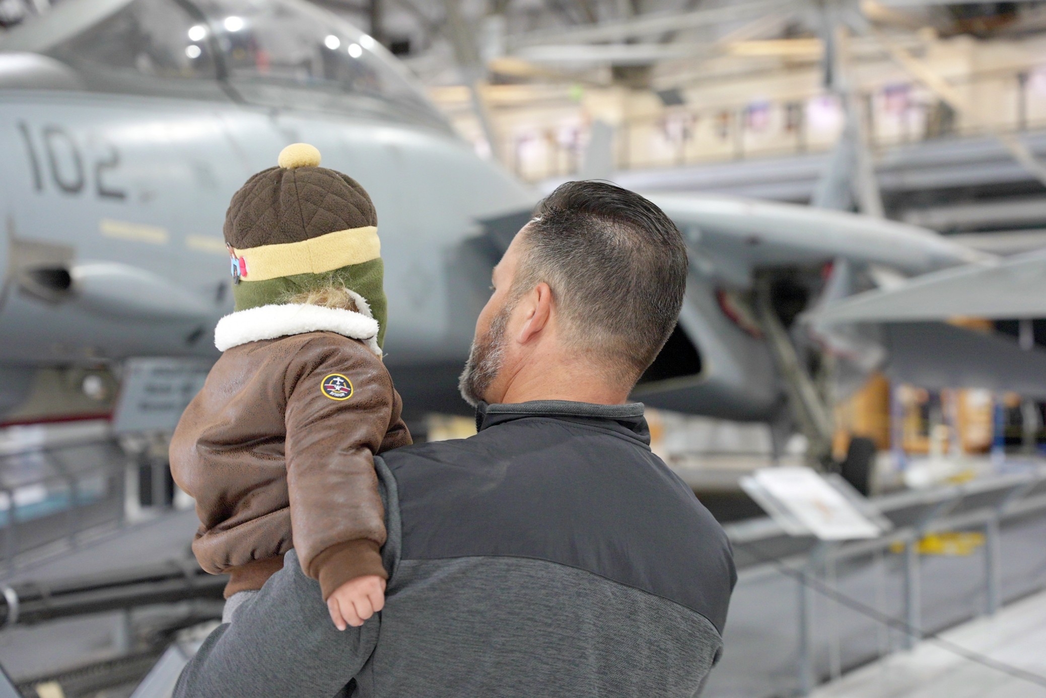 Dad holding son and viewing airplane