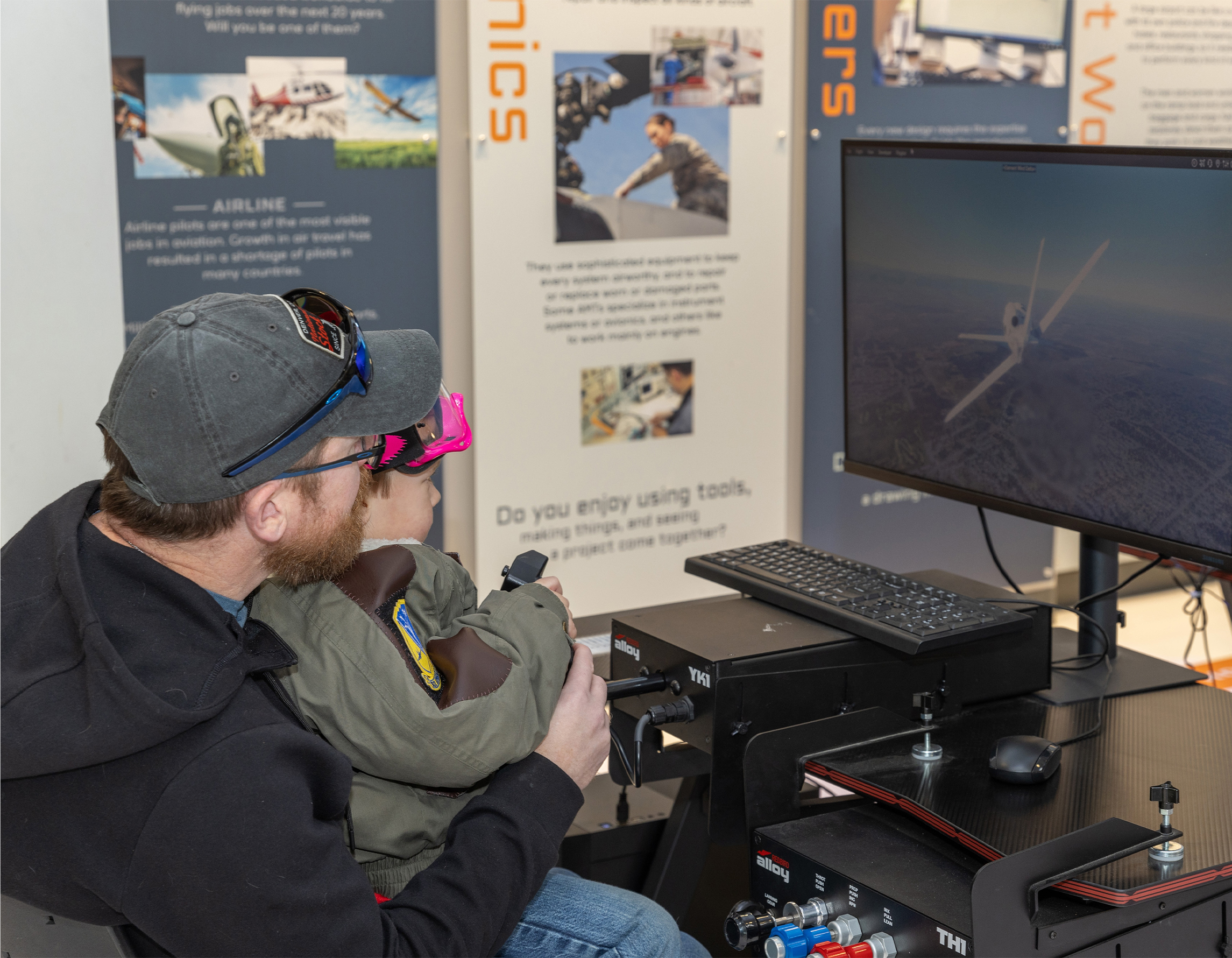 A man and child are using a simulator together.