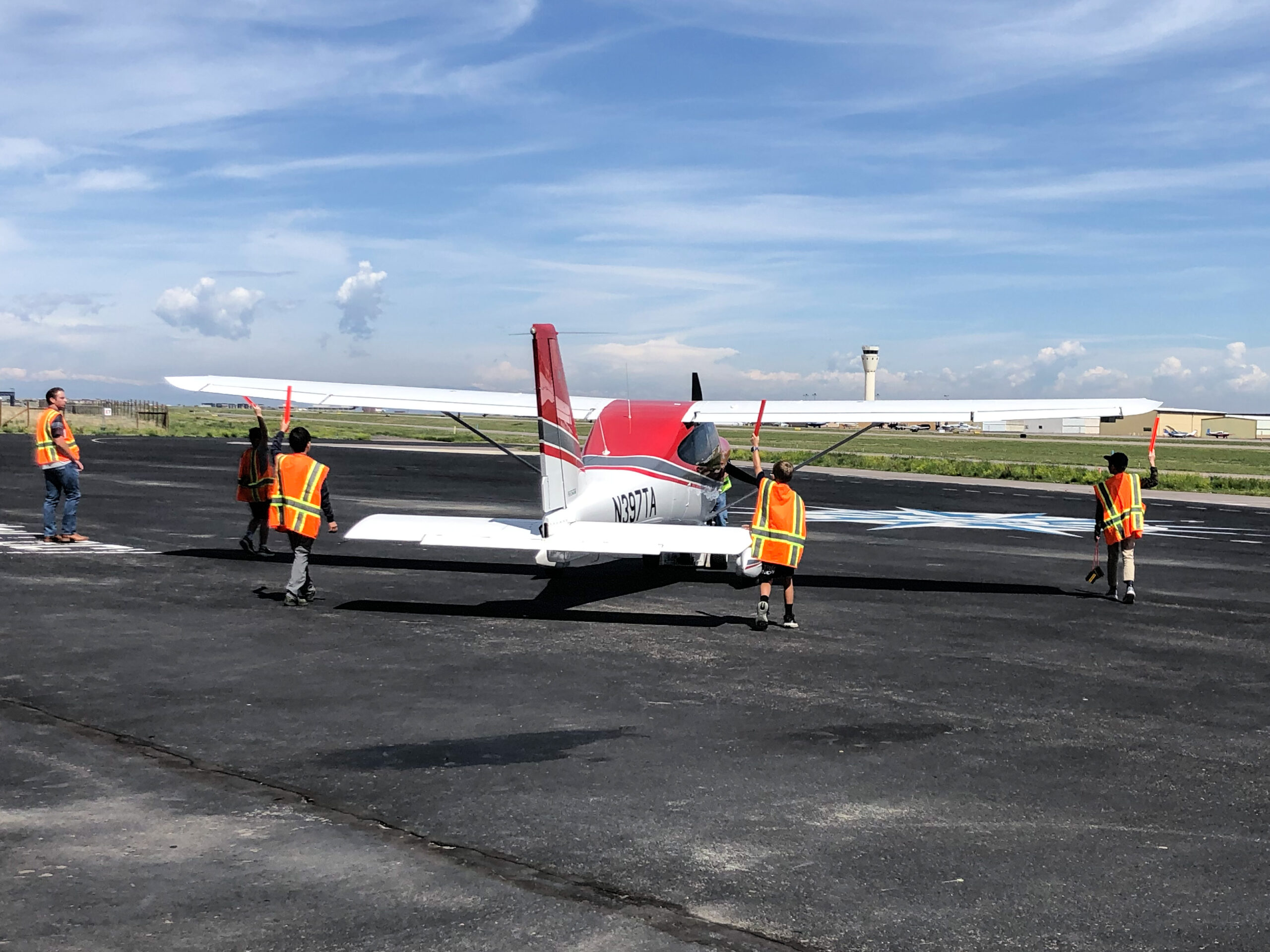 Students guiding a plane on the ramp