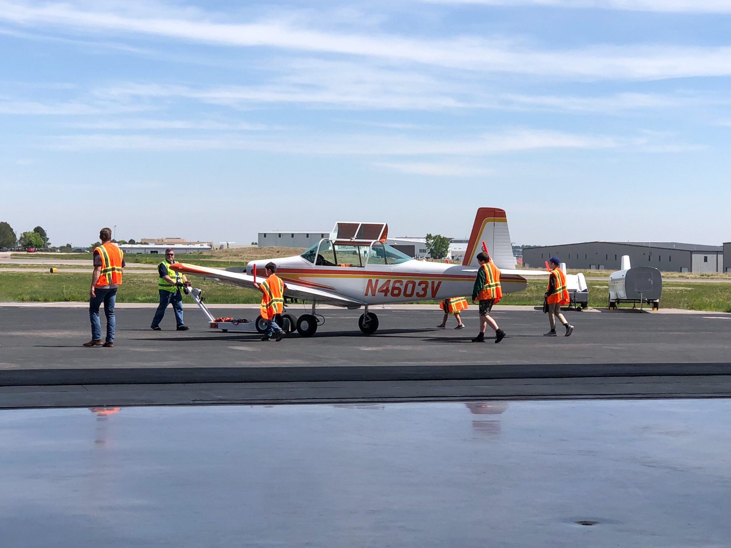 Students guiding an airplane on the ramp