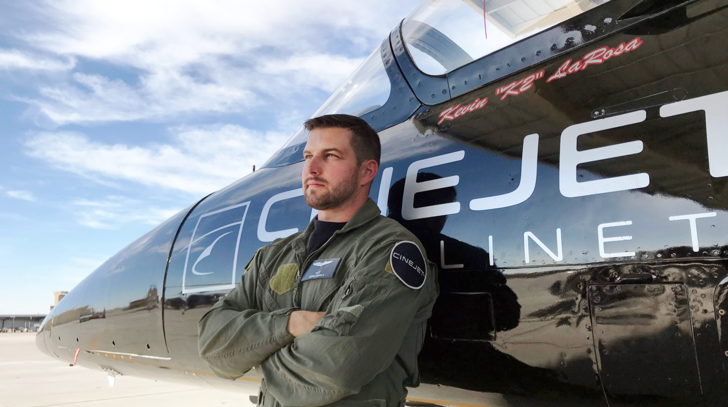 A picture of stunt pilot, Kevin LaRosa, standing in front of the nose of a plane.