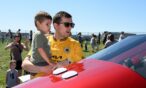 Father holding son as they check out aircraft on the ramp at Exploration of Flight