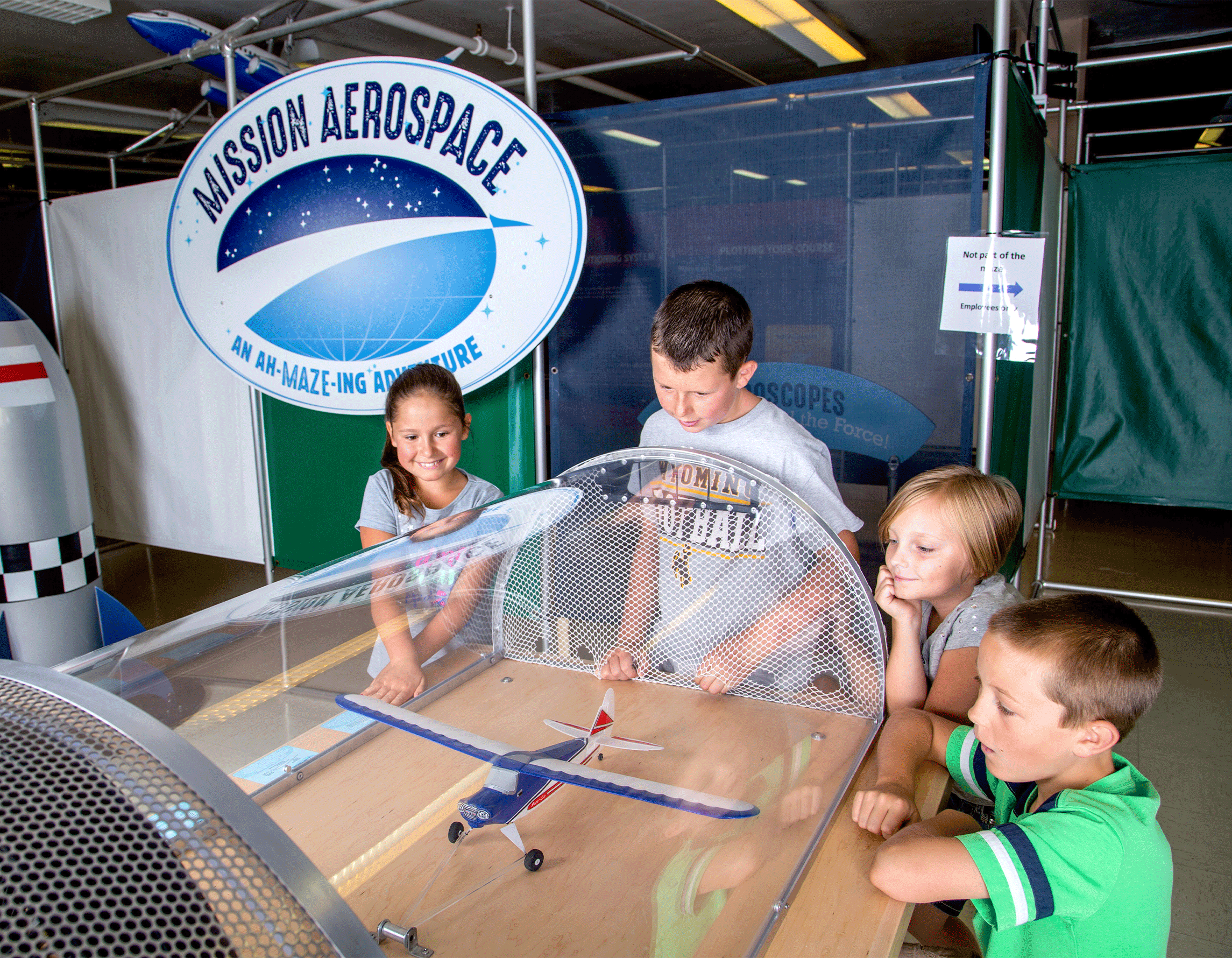Kids playing with interactive exhibit in Mission Aerospace