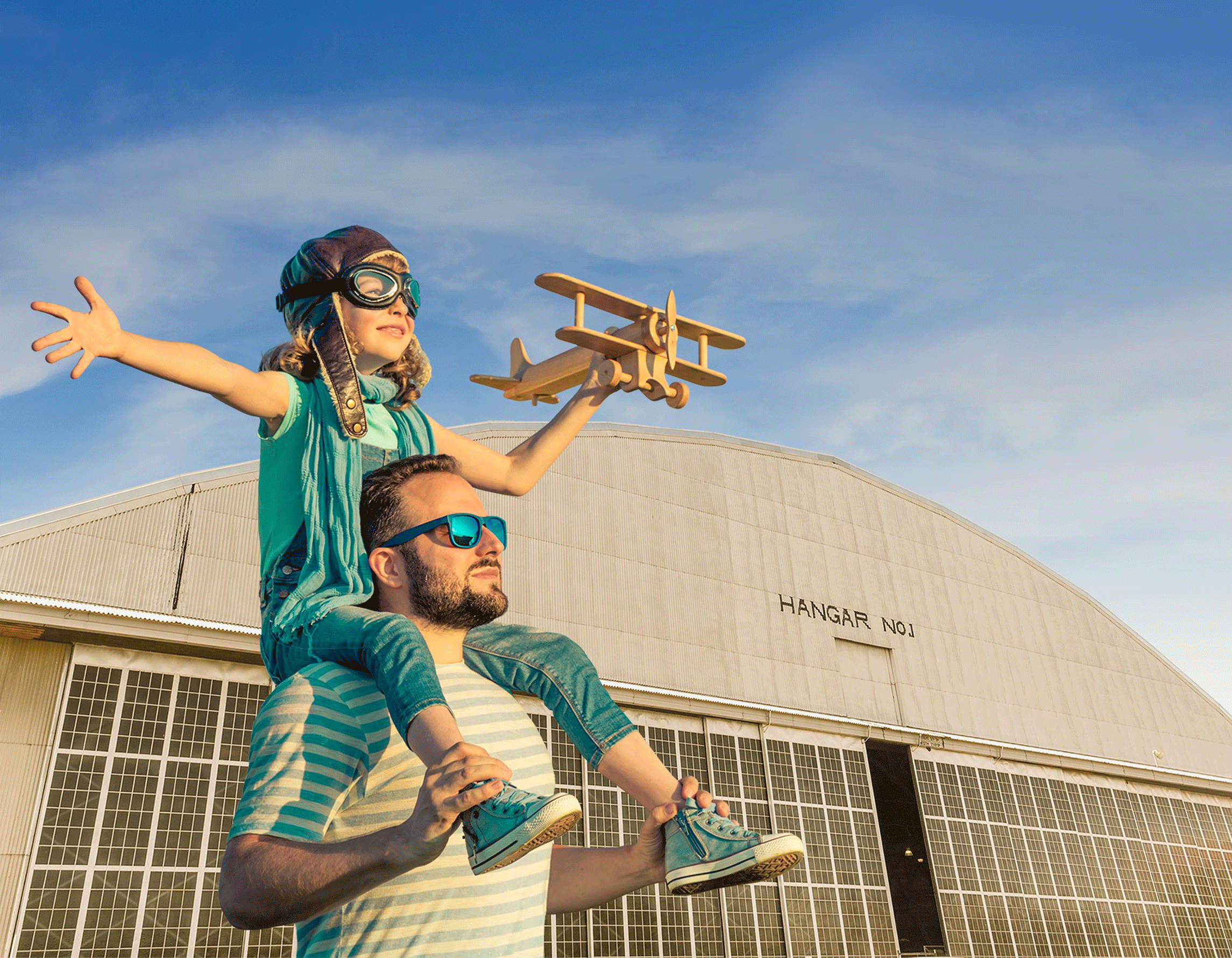Daughter on her dad's shoulders holding a toy airplane outside of the Air & Space Museum