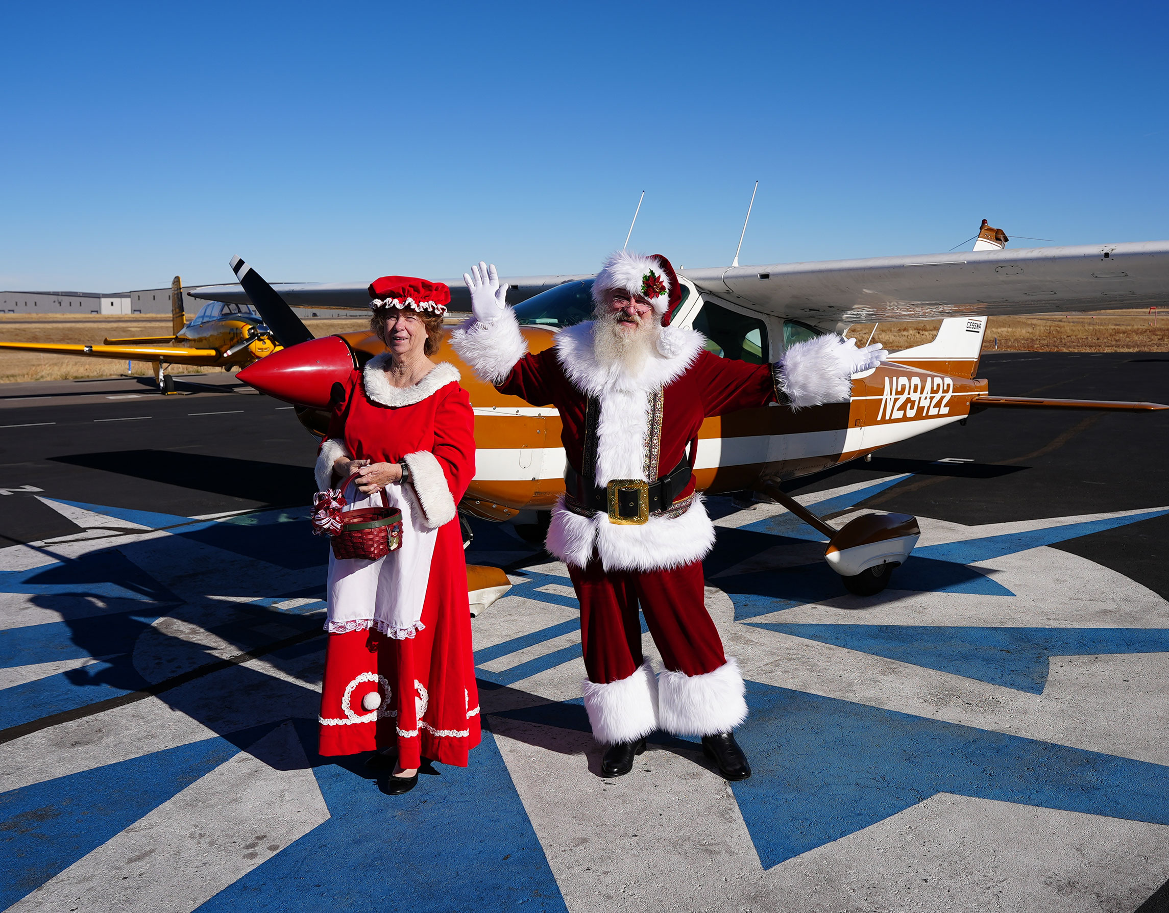 Santa and Mrs. Claus on the ramp by an airplane