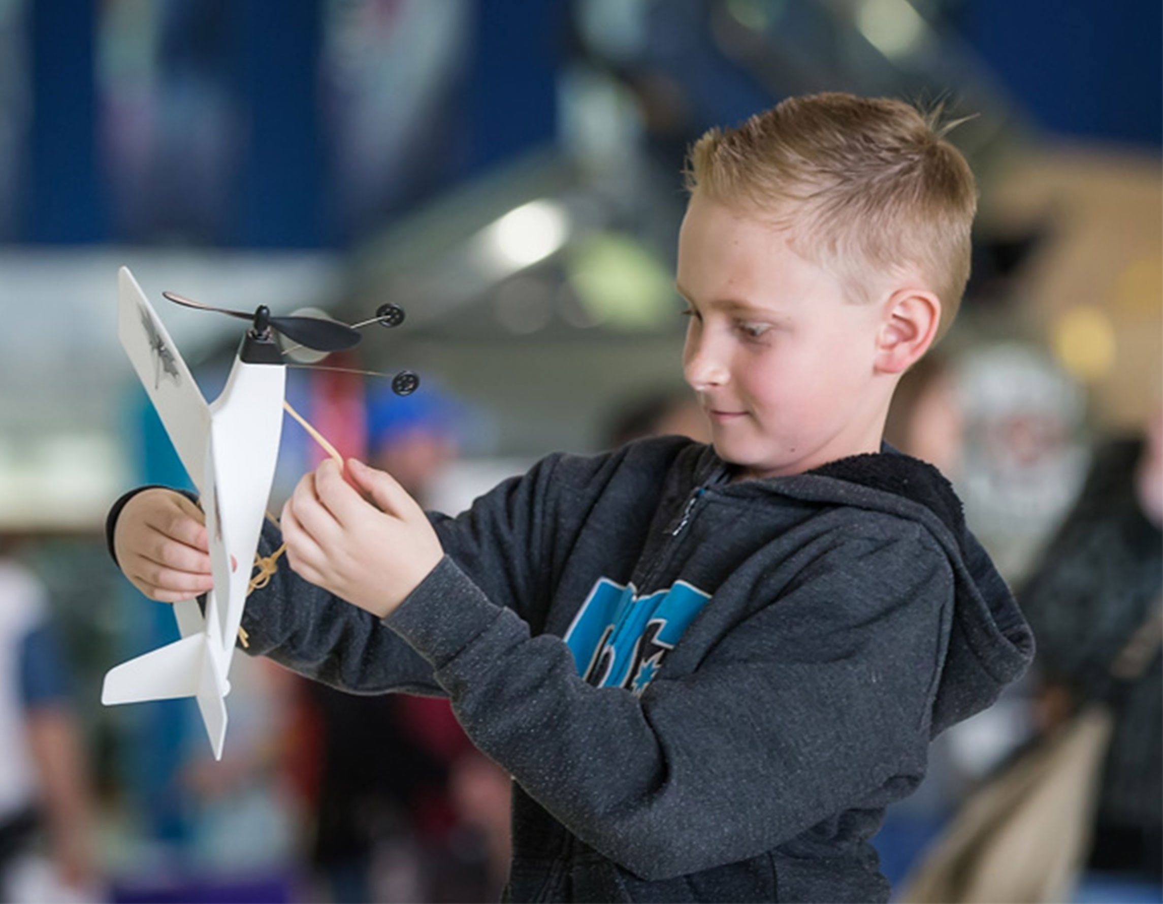 Student holding model airplane