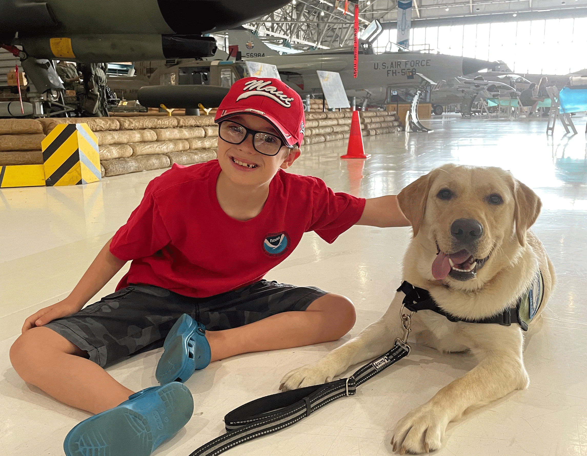 Kid with therapy dog in the hangar