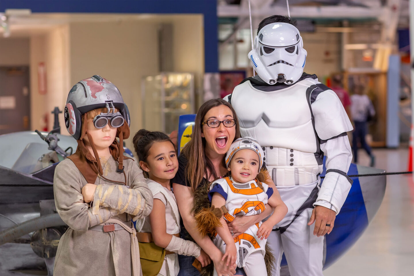 Family smiling next to Star Wars characters