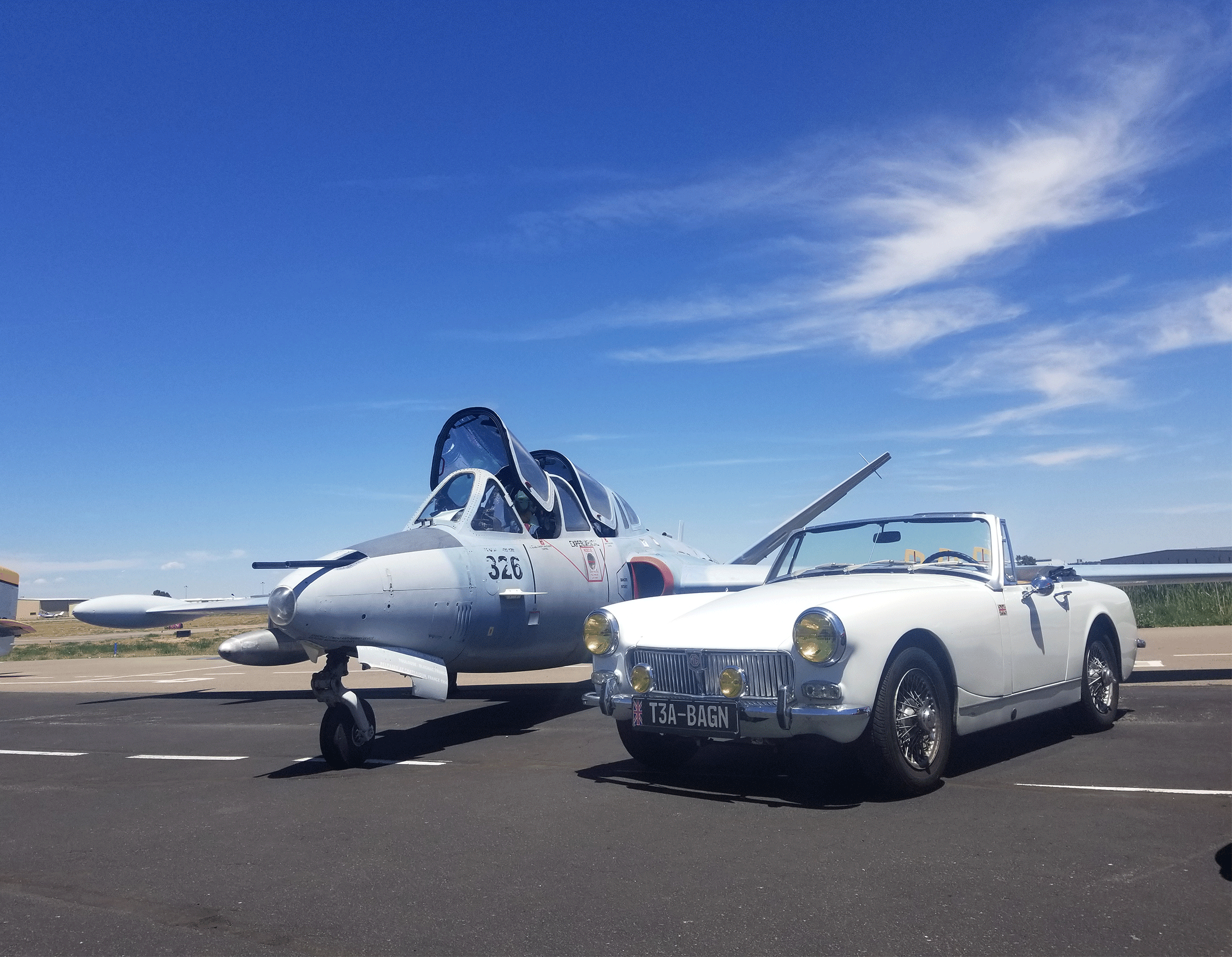 Vintage car next to airplane on the ramp