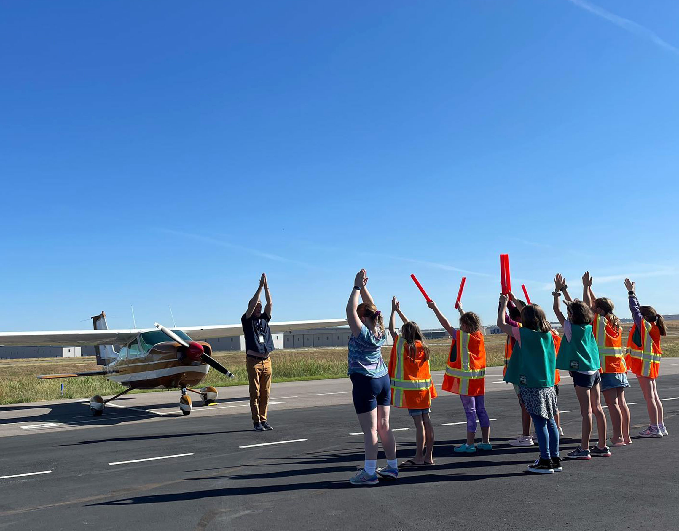 Girls on runway with flight instructor