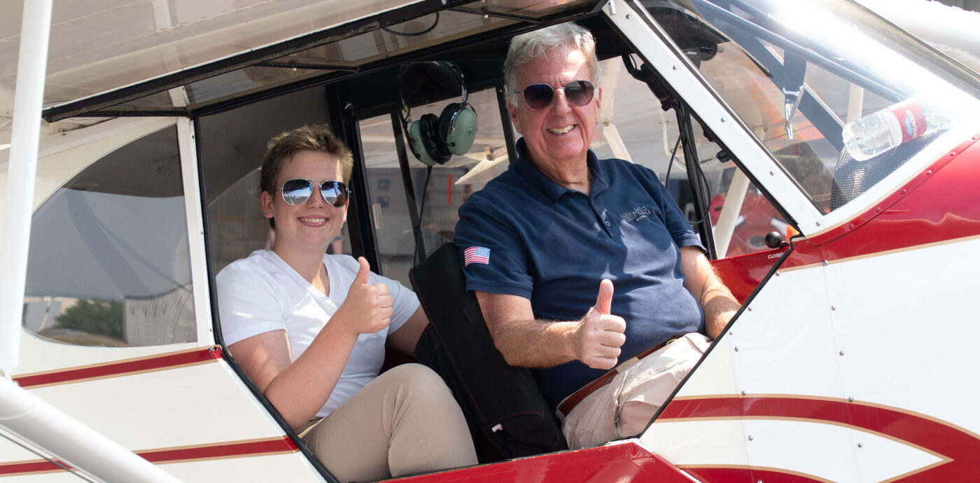Student and instructor in plane giving thumbs up