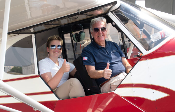 Student and instructor in plane giving thumbs up